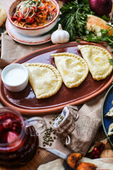 Muslim Ramadan iftar family dinner. Flat-lay of people feasting over table with Middle East food. Dates, dolma, kebab, flatbread, pide, borek, sweet, salad, top view. Ramazan fasting Turkish cuisine.