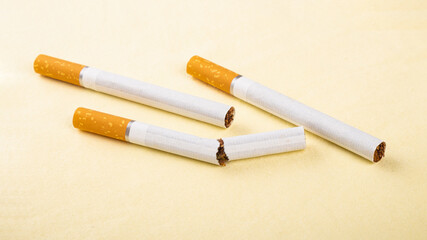 broken cigarette on yellow background, no smoking concept, bad habit, harm from smoking