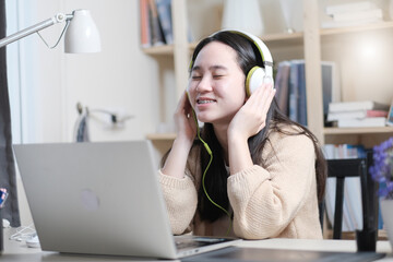  Asian teen girl listening to music with headphone,