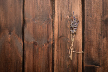 Dried lavender stems flowers on the brown wooden table background with copy space.