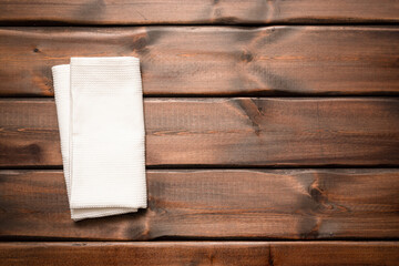 White towel on the brown wooden table background with copy space top view.