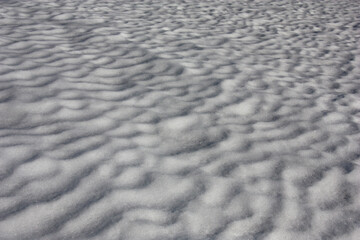 Snow cover in the spring. Wavy surface and brilliant crust. Play of light and shadow.
