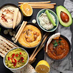 Different kinds of hummus dips with snacks