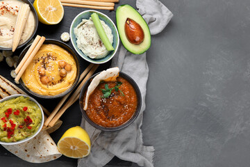 Different kinds of hummus dips with snacks