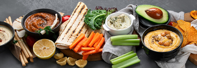 Different kinds of hummus dips with snacks