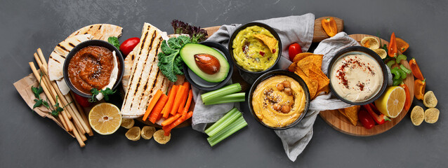 Different kinds of hummus dips with snacks