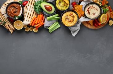 Different kinds of hummus dips with snacks