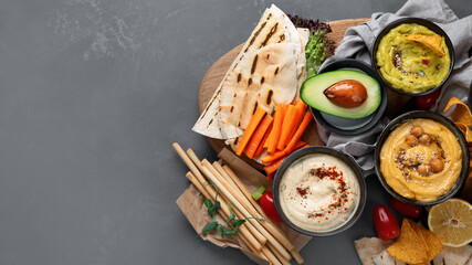 Different kinds of hummus dips with snacks