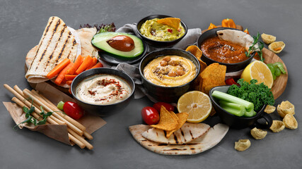 Different kinds of hummus dips with snacks