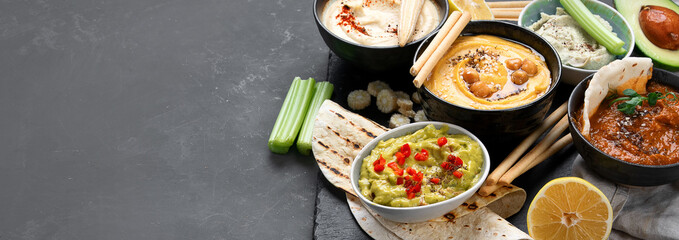 Different kinds of hummus dips with snacks
