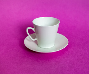 White purchased porcelain coffee Cup with saucer closeup on pink background