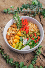 Matcha green tea breakfast superfoods smoothies bowl topped with chia, flax and pumpkin seeds, bee pollen, granola, coconut flakes, kiwi and strawberry. top view, flat lay