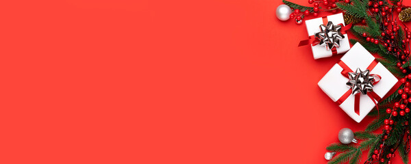 Christmas decorations on the red background. Flat lay, top view with copy space for your text, wide angle view. Banner.