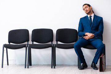 Young businessman waiting for an interview at hall