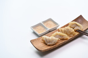 A plate of Japanese gyoza dumplings putting on a white table.