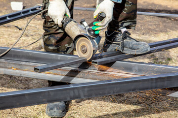 A worker cuts metal at a construction site. Technology