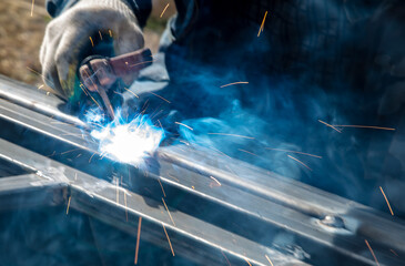 A worker welds metal at a construction site. Technology
