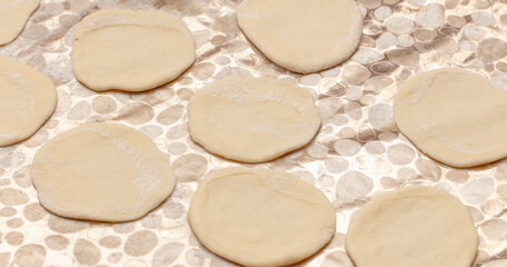 Modeling dumplings from dough on the table.