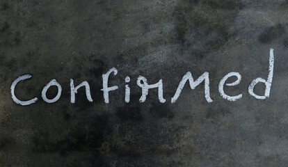 Fototapeta premium Confirmed Word Written on Blackboard with White Chalk