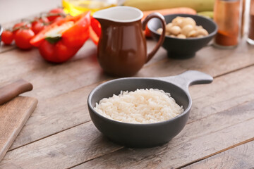 Bowl with boiled rice on table