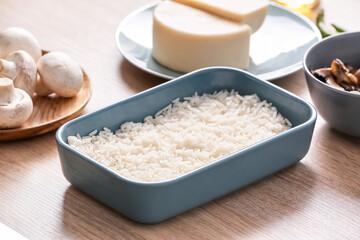 Baking dish with boiled rice on table