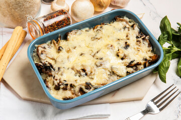 Baking dish with tasty rice casserole on white background
