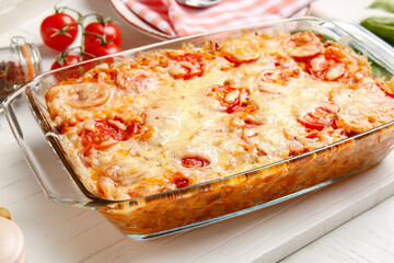 Baking dish with tasty rice casserole on table