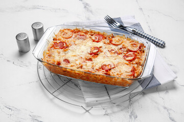 Baking dish with tasty rice casserole on white background