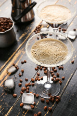 Glasses of tasty espresso martini cocktail on wooden background