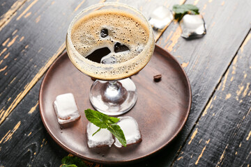 Glass of tasty espresso martini cocktail on wooden background