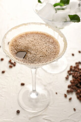 Glass of tasty espresso martini cocktail on light background
