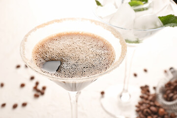 Glass of tasty espresso martini cocktail on light background