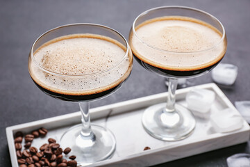 Tray with two glasses of tasty espresso martini cocktail on table