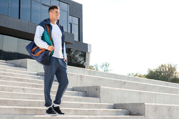 Sporty young man with bag outdoors