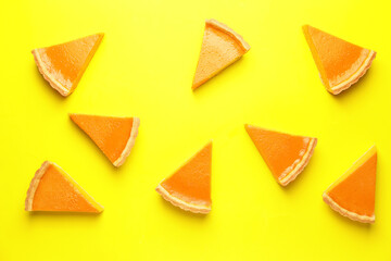 Slices of tasty pumpkin pie on color background
