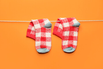 Rope with warm socks on color background