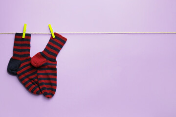 Rope with warm socks on color background