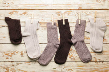 Rope with warm socks on wooden background