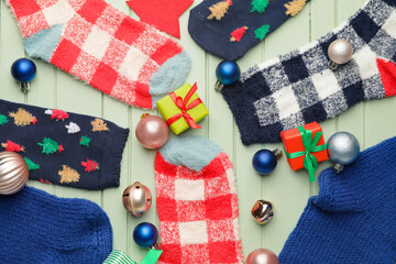 Fototapeta na wymiar Warm socks and Christmas decor on color wooden background