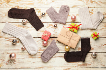 Warm socks and Christmas decor on wooden background
