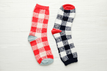 Warm socks on white wooden background