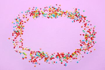 Frame made of sweet colorful sprinkles on color background