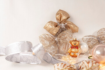 Christmas background with golden bow. New Year's decor. Christmas balls and golden bear. White background