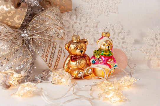 Christmas background with golden stars. New Year's decor. Christmas ball and golden bear. White snowflakes.