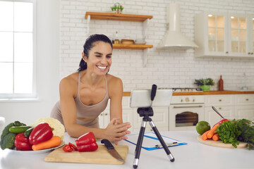 Smiling fitness vlogger recording video on vegetarian diet and healthy eating habits