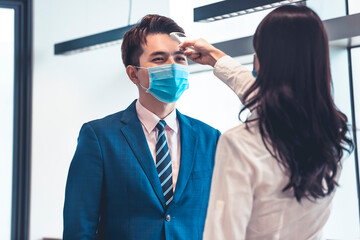 Business people check temperature measurement by infrared digital thermometer before working