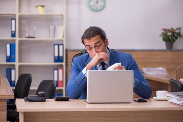 Young sick businessman employee suffering at workplace