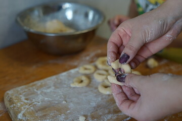 Hands that make doughnuts out of dough
