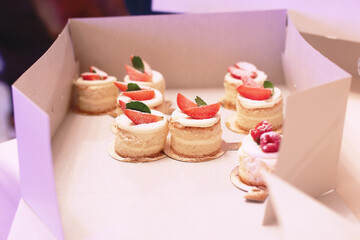 Catering table with sliced chocolate cakes decorated with fresh raspberries and nuts.