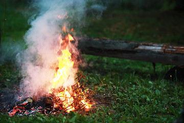 Burning red hot sparks fly from big fire. Burning coals, flaming particles flying off against black background.